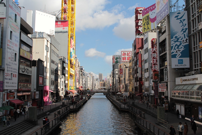 Canal de Osaka al anochecer, con edificios reflejados en el agua.